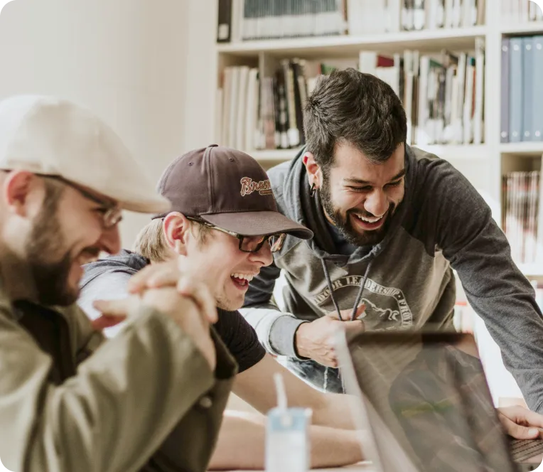Group of young people looking at screen and laughing